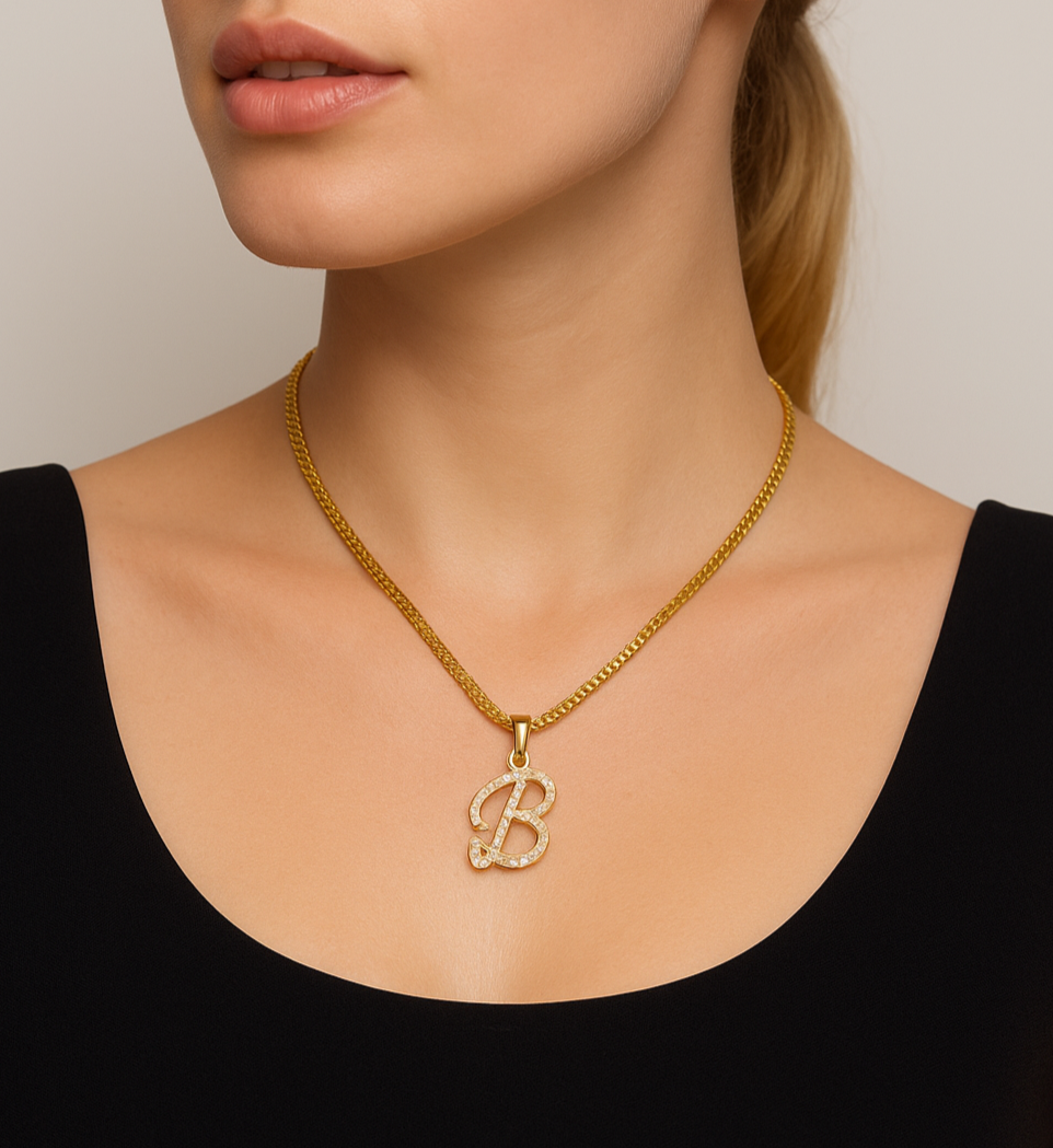 Woman wearing a gold necklace with a 'B' pendant against a neutral background