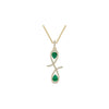 Gold necklace with a pendant featuring green gemstones on a white background