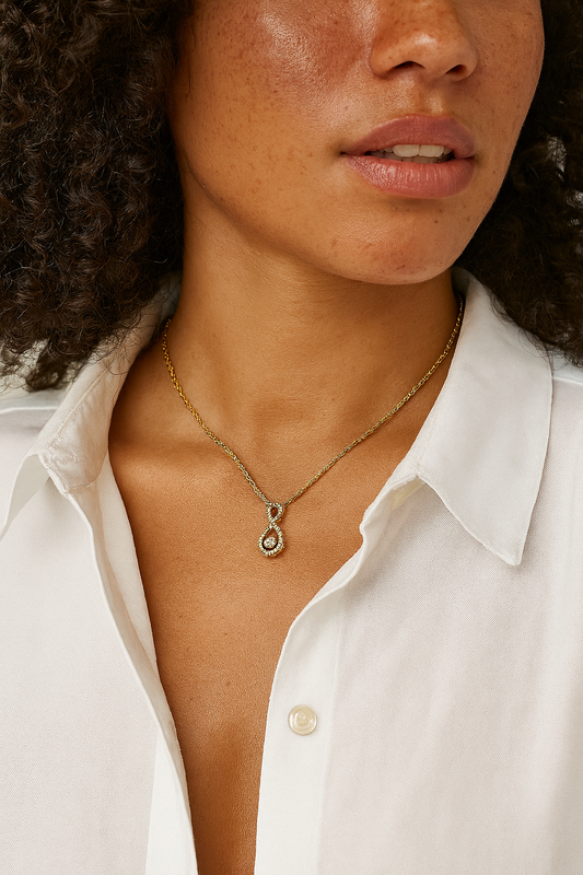 Close-up of a person wearing a gold necklace with a pendant.